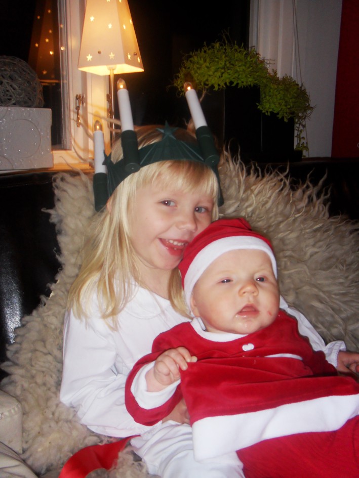 Alice Valbäck 3 år och Edith Valbäck 4 mån, i Stöcke, lussar för farmor, farfar och Johannes och med dagisbarnen på Kornet. De hälsar God Jul till alla de känner.